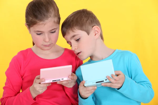 Crianças brincando com consola de jogo portátil — Fotografia de Stock