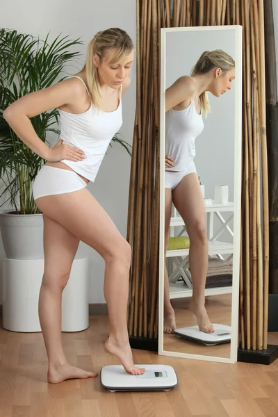 Blonde vrouw met een gewicht van zichzelf — Stockfoto
