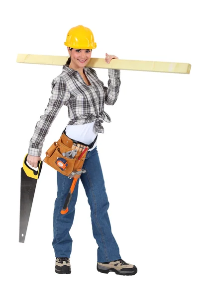 Carpinteiro fêmea transportando prancha de madeira — Fotografia de Stock