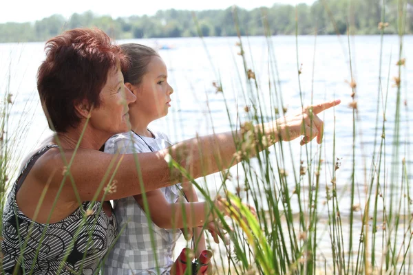 Женщина и маленькая девочка на берегу реки — стоковое фото