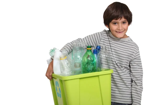Ребенок улыбается, держа мусорное ведро — стоковое фото