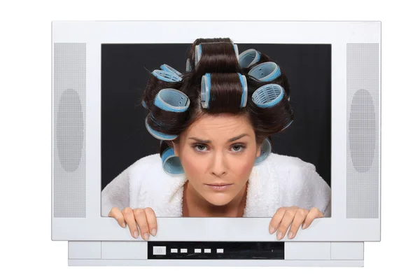 Mulher em rolos de cabelo preso na televisão — Fotografia de Stock