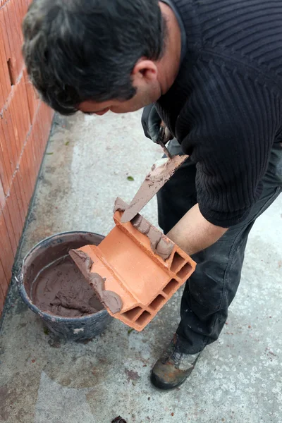 Mason zastosowanie cementu na cinderblock — Zdjęcie stockowe