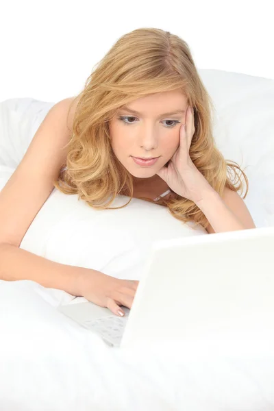 Frau mit Computer im Bett — Stockfoto
