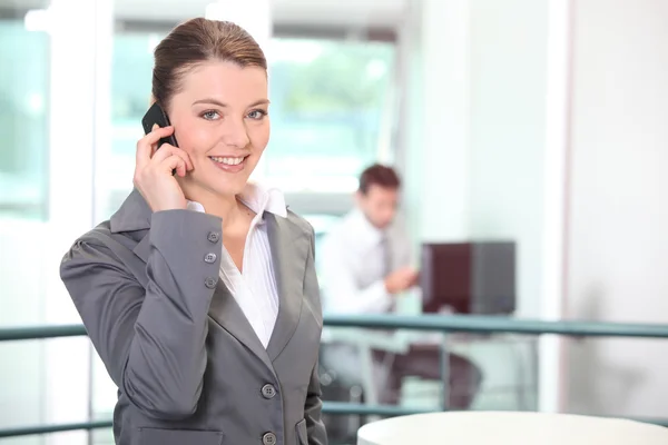 Giovane donna d'affari che fa una chiamata in ufficio — Foto Stock