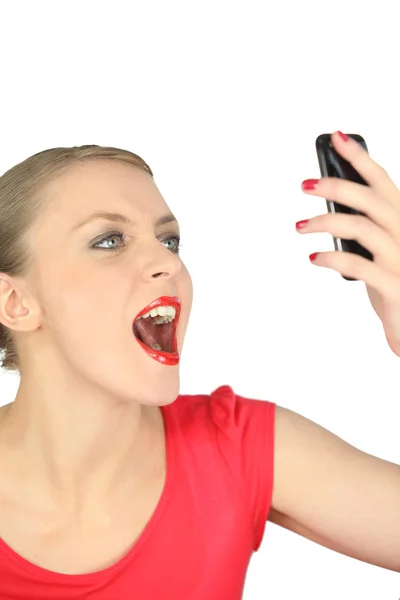 Женщина смотрит на свой мобильный телефон с неверием — стоковое фото