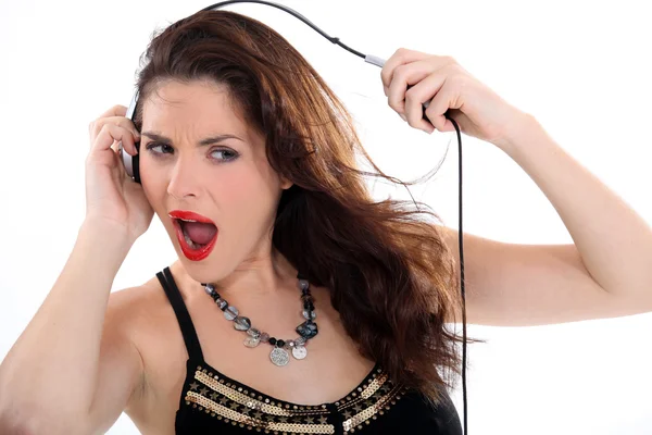 Szalona kobieta rozciąganie jej słuchawki — Zdjęcie stockowe