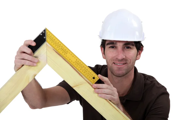 Mann benutzt Quadrat auf Holzrahmen — Stockfoto