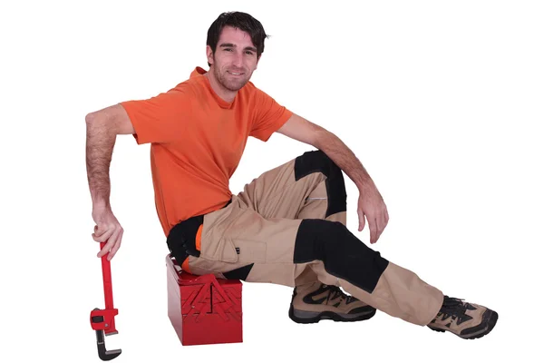 Mann sitzt auf Werkzeugkiste — Stockfoto