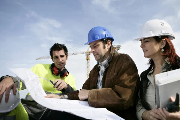 Trabajadores de la construcción discutiendo planes — Foto de Stock