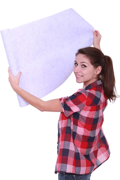 Jeune femme déroulant papier peint — Photo