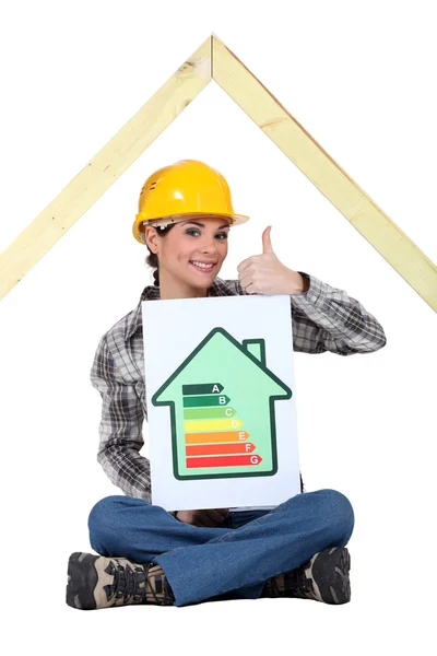 Construtora de casa feminina com um sinal de classificação de energia — Fotografia de Stock