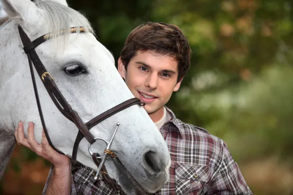 Подросток с белой лошадью — стоковое фото