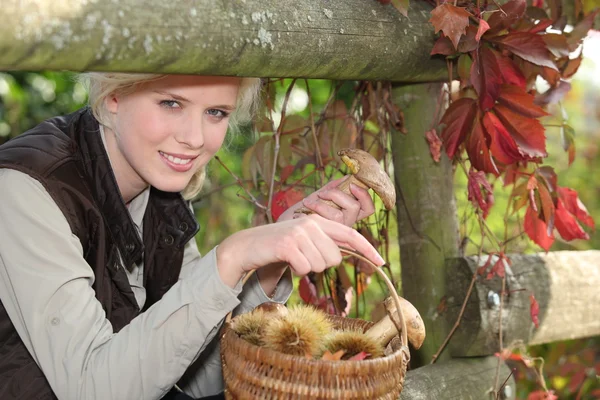 Frau mit Korb mit Kastanien und Pilzen — Stockfoto