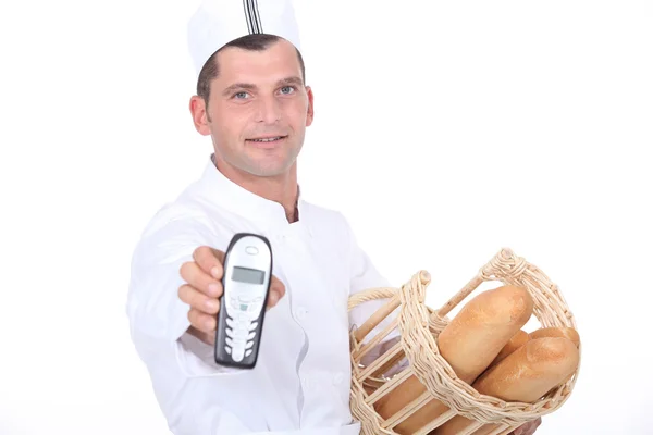 Пекарь с корзиной и телефоном — стоковое фото