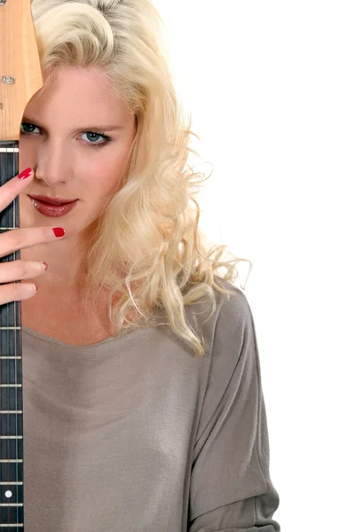 Schöne Frau guckt hinter ihrer Gitarre hervor — Stockfoto