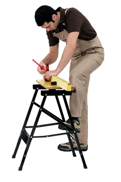 Workman marcando uma medição em uma prancha de madeira — Fotografia de Stock