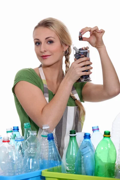Женщина перерабатывает батарейки и пластиковые бутылки — стоковое фото