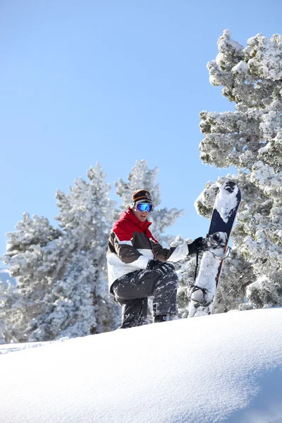 Homem snowboard descendo colina nevada — Fotografia de Stock