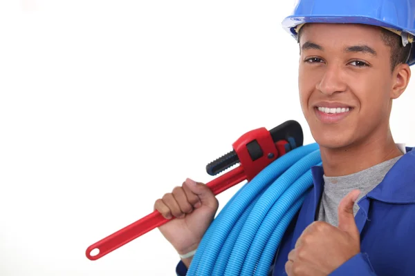 Plumber with plastic piping and wrench — Stock Photo, Image