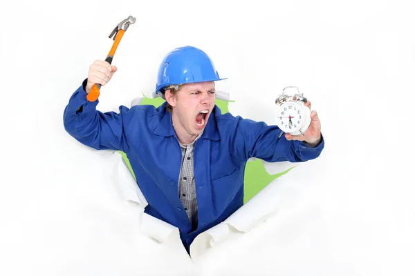 Hombre enojado sosteniendo un martillo y un despertador — Foto de Stock