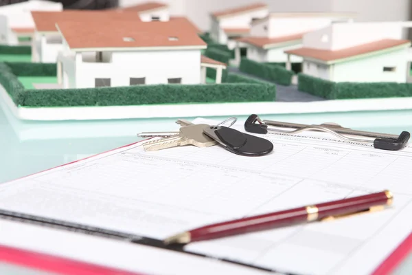 Clipboard next to a model housing estate — Stock Photo, Image