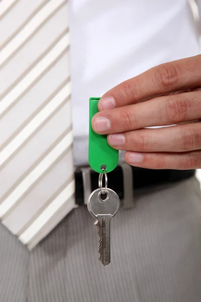 Mano del agente inmobiliario que sostiene la llave — Foto de Stock