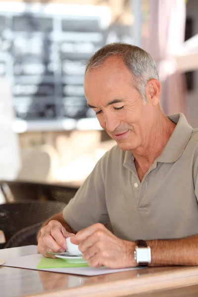 Hombre de pelo gris se sentó en la cafetería bebiendo espresso —  Fotos de Stock