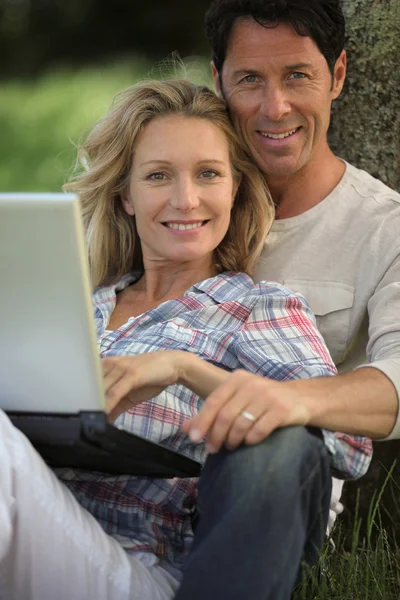 Ευτυχισμένο ζευγάρι σε εξωτερικούς χώρους με φορητό υπολογιστή — Φωτογραφία Αρχείου