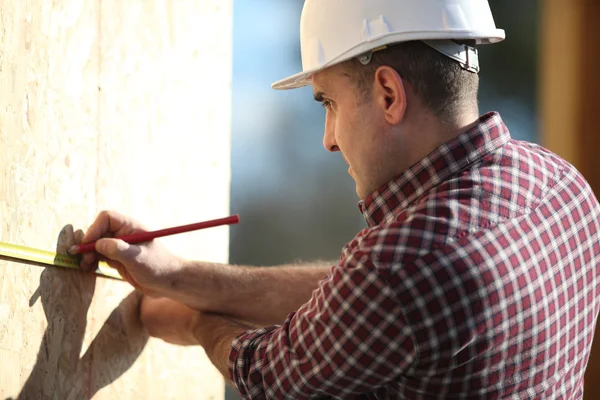 Construction worker marking wooden frame — Stock Fotó