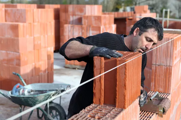 Arbeiter baut eine Mauer — Stockfoto