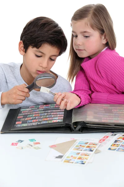 Zwei Kinder sammeln Briefmarken. — Stockfoto