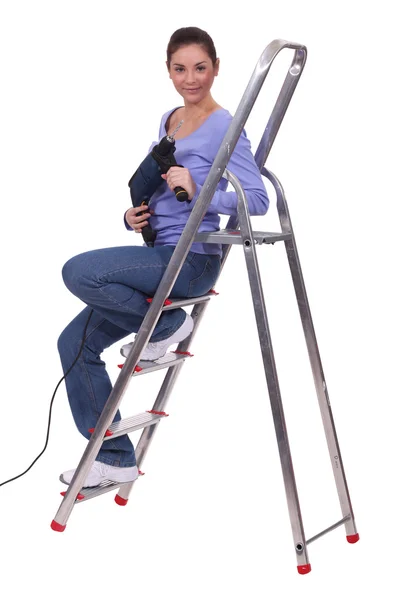 Frau sitzt mit Bohrer auf Treppe — Stockfoto