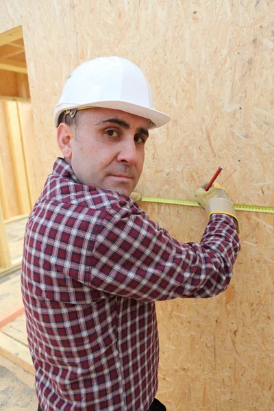 Constructeur mesurant un mur — Photo