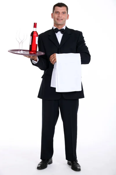 Servitören håller bricka med vinflaska — Stockfoto