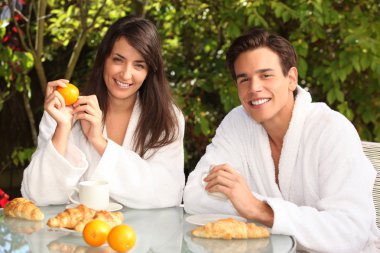 Couple having breakfast in the garden clipart