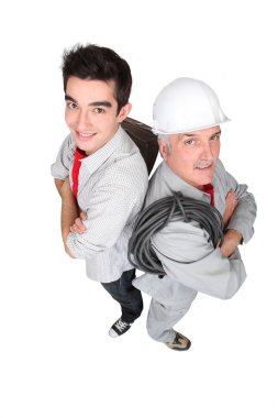 Electrician stood with young probationer clipart