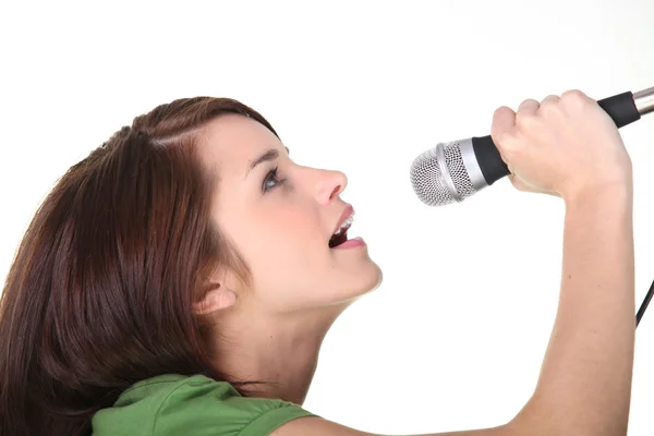 Studioaufnahme einer jungen Frau, die in ein Mikrofon singt — Stockfoto