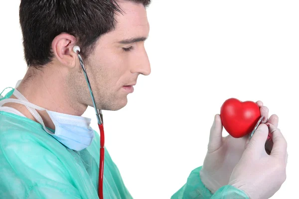 Lekarz słuchać palenisko czerwony zabawka — Zdjęcie stockowe