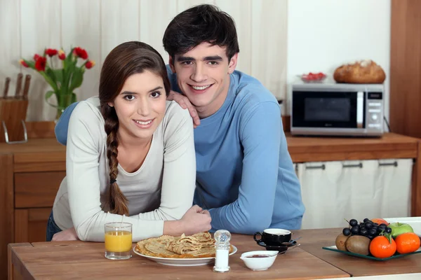 Jeune couple ayant des pancakes pour le petit déjeuner — Photo