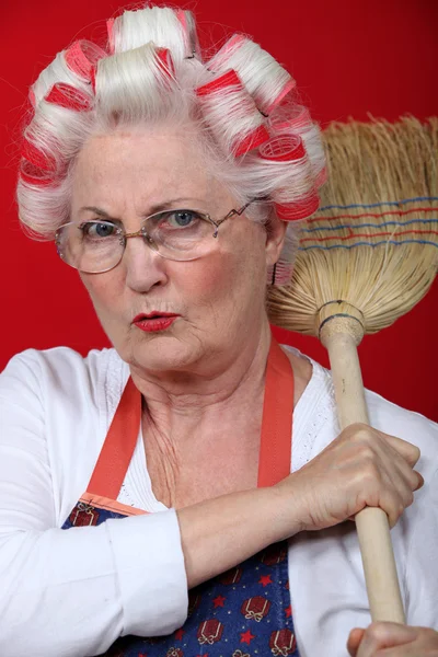 Senior woman holding a broom — Stock Photo, Image