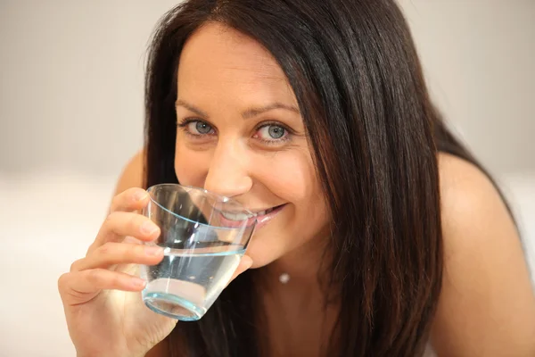 水のガラスを飲むブルネット — ストック写真