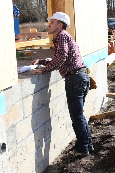 Foreman inspecionando casa de madeira inacabada — Fotografia de Stock