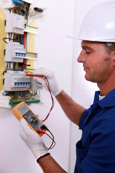 Eletricista inspecionando caixa de fusíveis — Fotografia de Stock