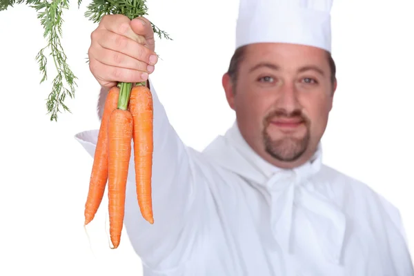 Chef sosteniendo un montón de zanahorias — Foto de Stock