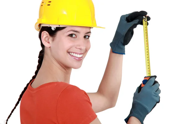 Young female laborer using measuring tape — Stock Fotó
