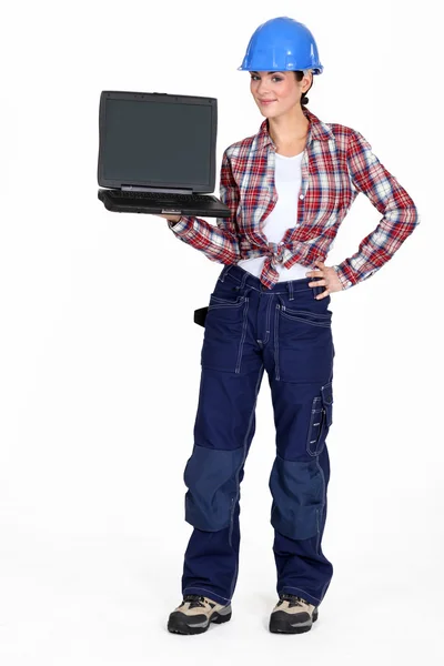 Uma trabalhadora de construção feminina segurando um laptop . — Fotografia de Stock