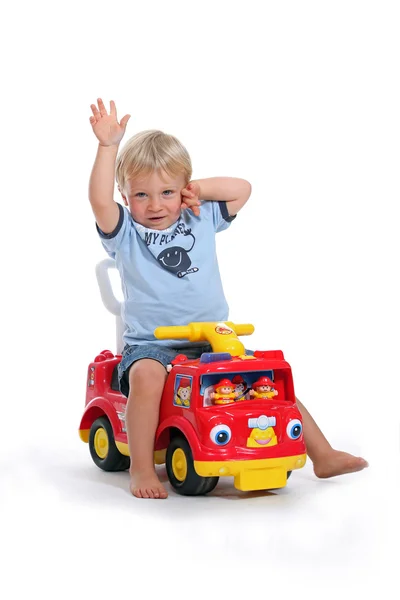 Portret van een kind op speelgoedauto — Stockfoto