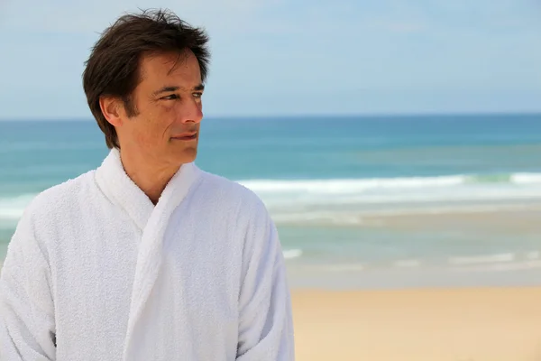 Man in bathrobe on the beach — Stock Photo, Image