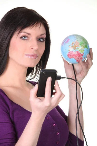 Woman plugging her cellphone into the world — Stock Photo, Image